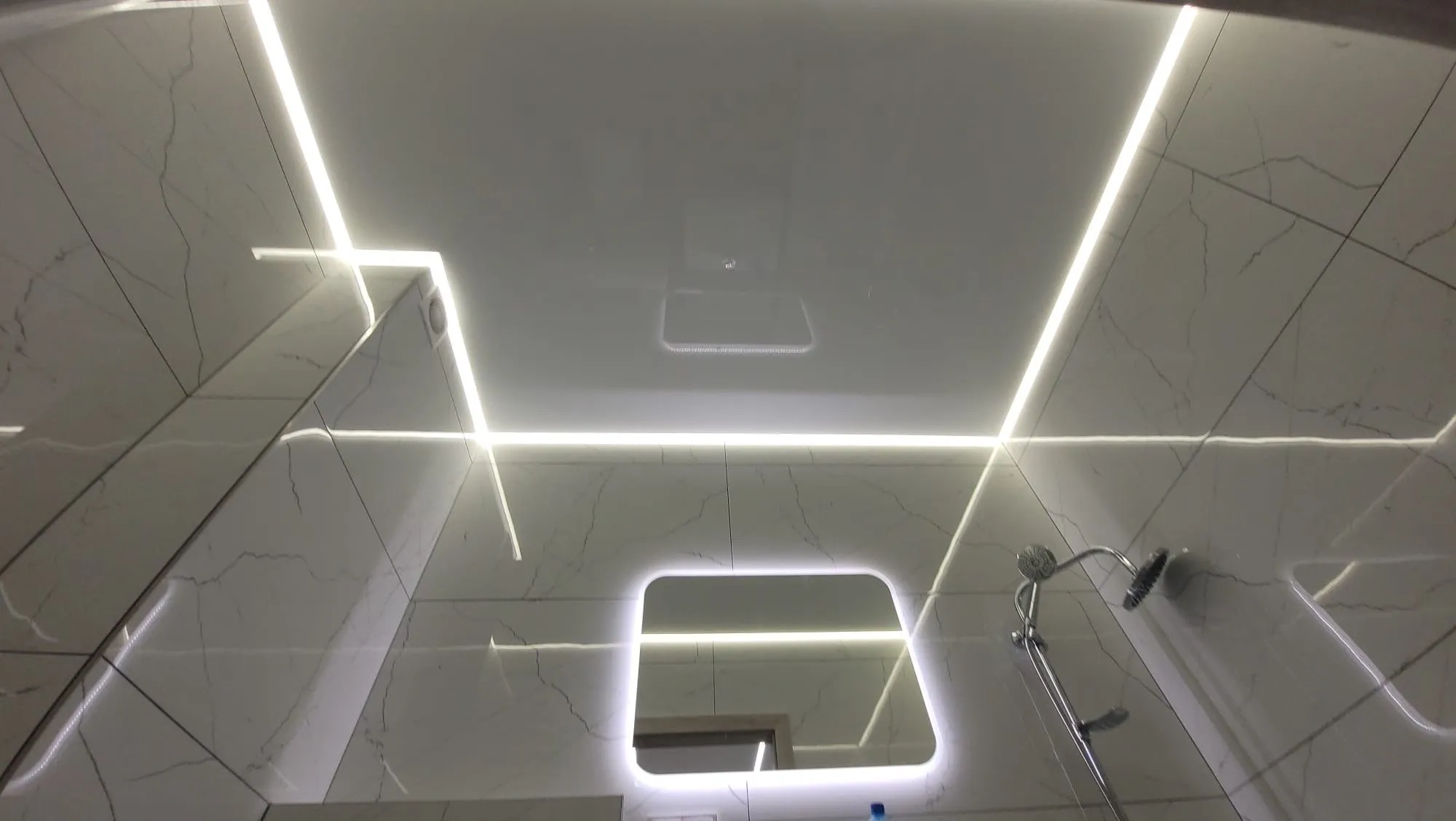 Sufit lustrzany z liniami LED w łazience